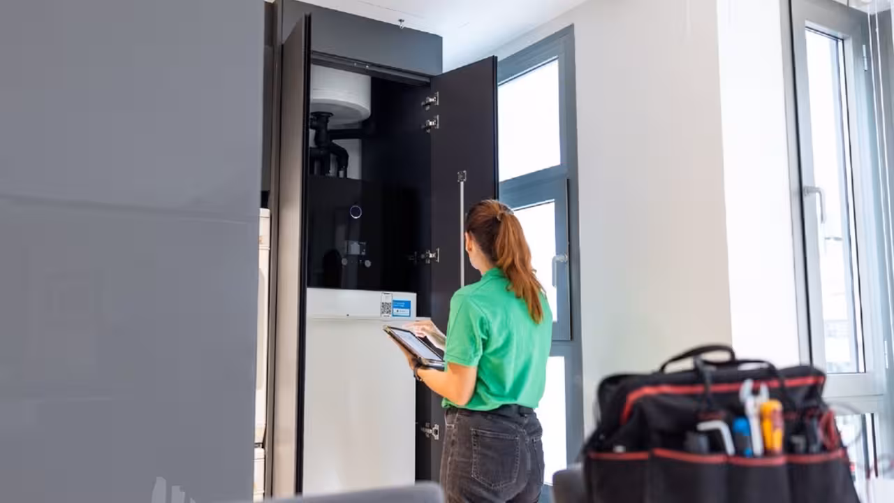 Técnico de Iberdrola ante la unidad interior de aerotermia en una vivienda